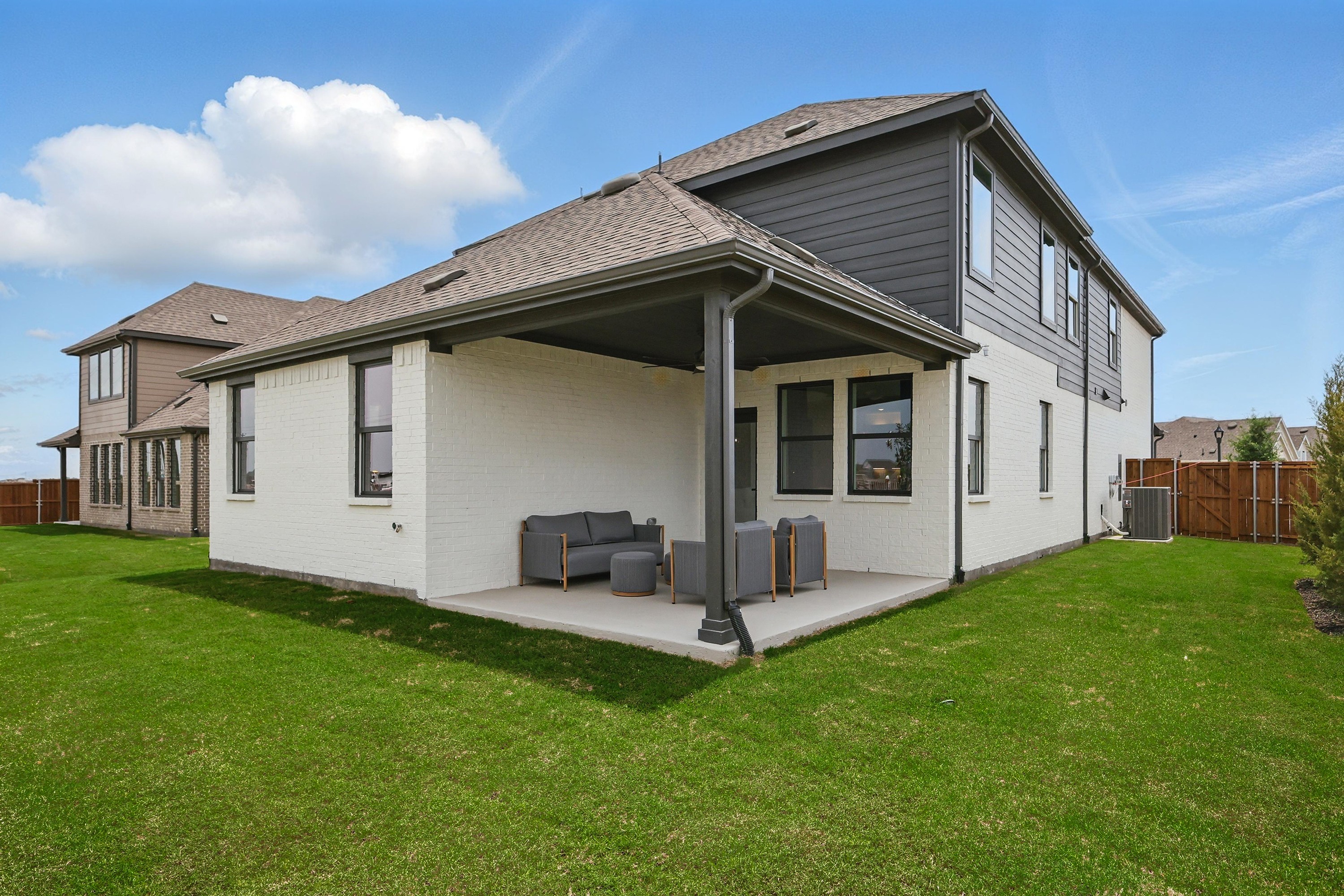 Modern two-story house with covered patio, brick facade, and manicured lawn in Westridge community, Texas.
