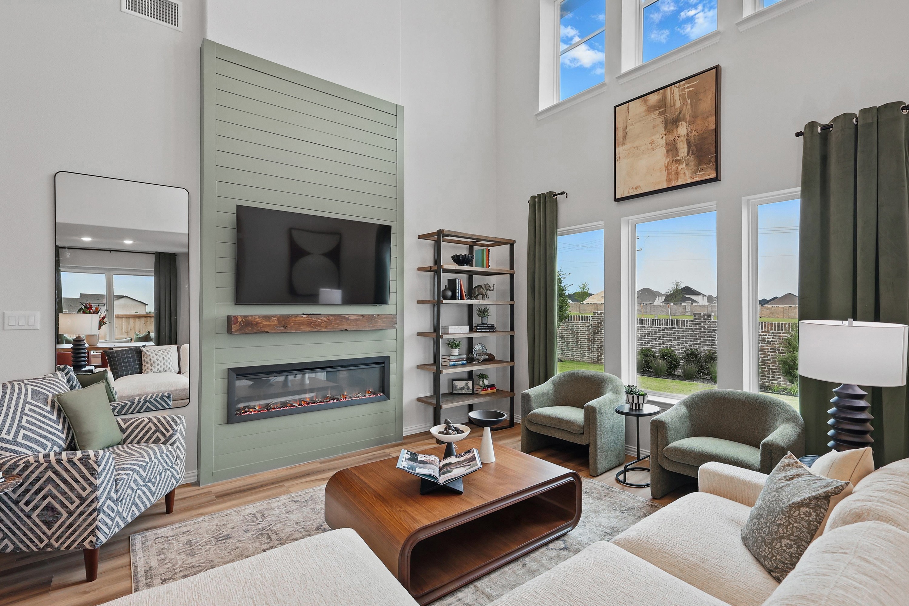 Modern living room, high ceilings, large windows, green shiplap fireplace, Westridge. Cozy seating arrangement.