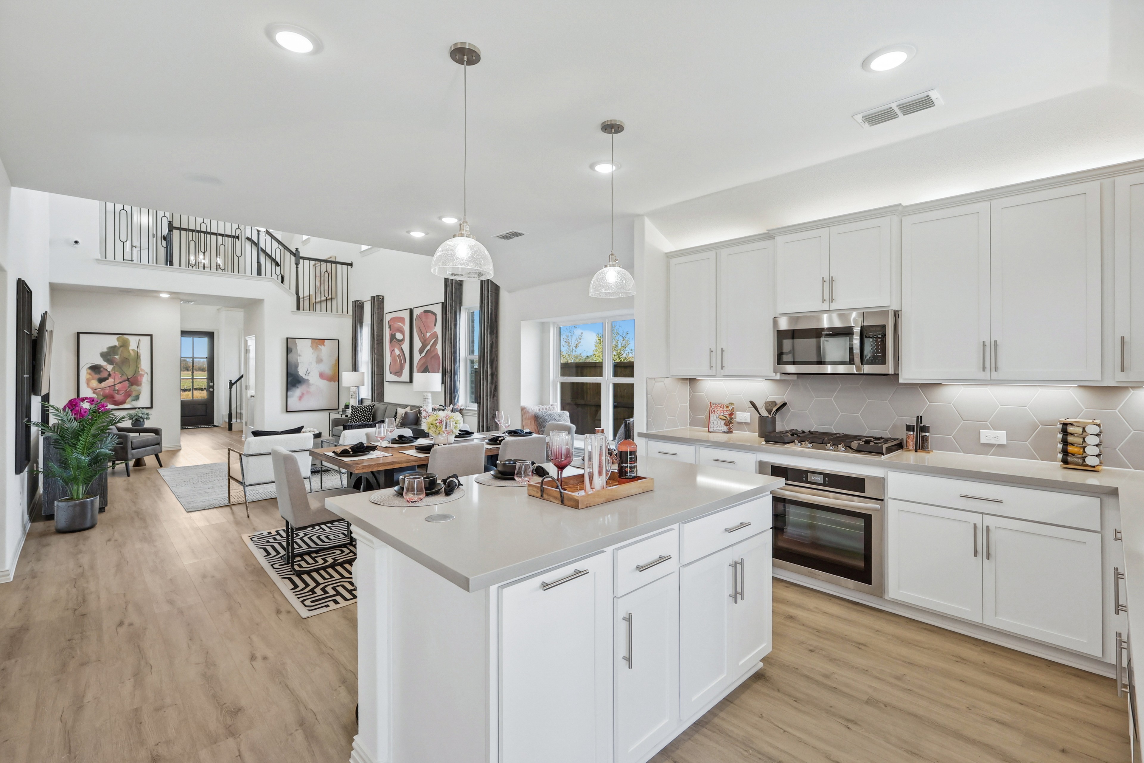 Elegant Bel Air Village kitchen with white cabinetry, pendant lights, wood flooring, open layout, dining area view.