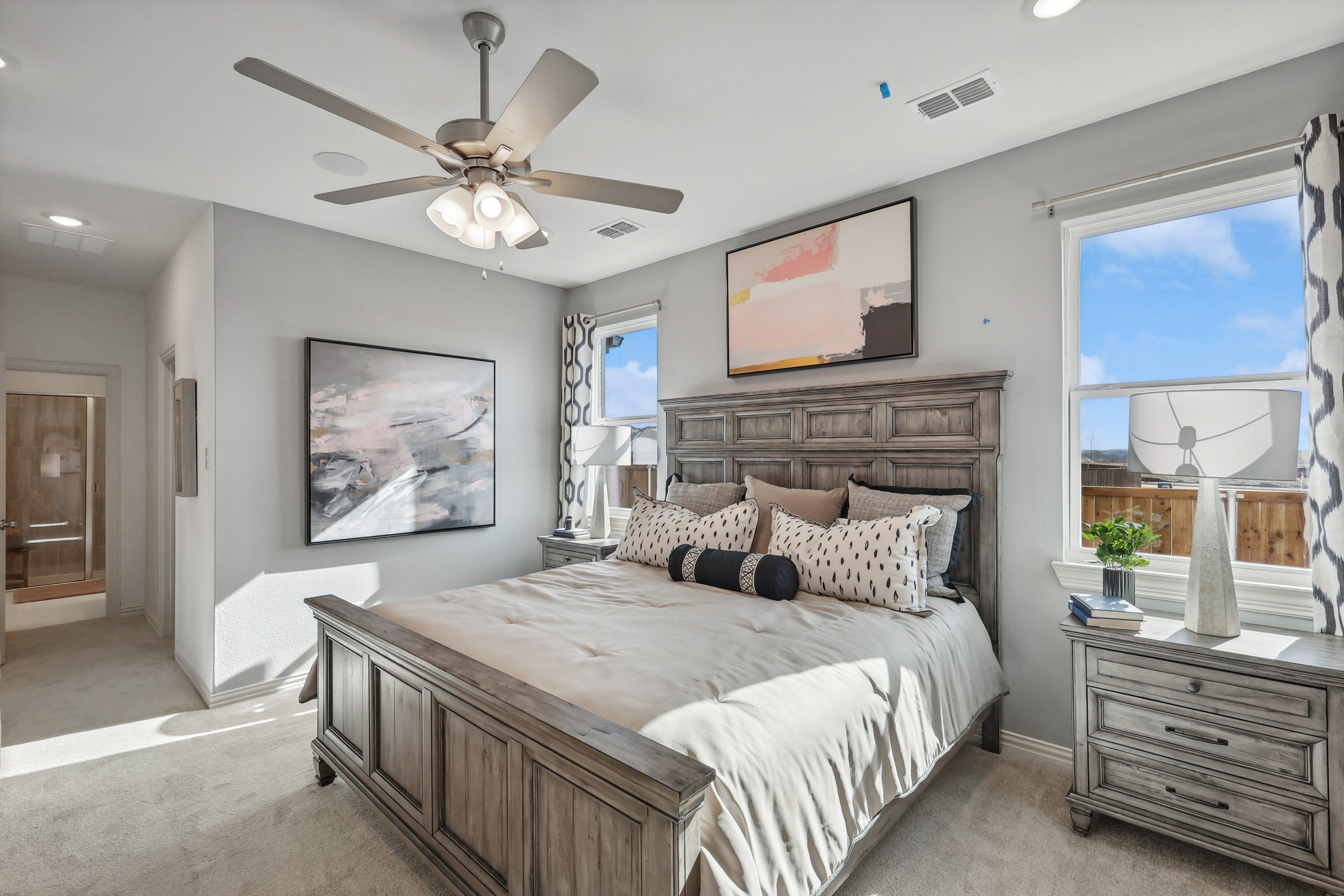 Elegant bedroom in Bel Air Village with wooden furniture, modern art, and natural light. Luxurious and serene atmosphere.