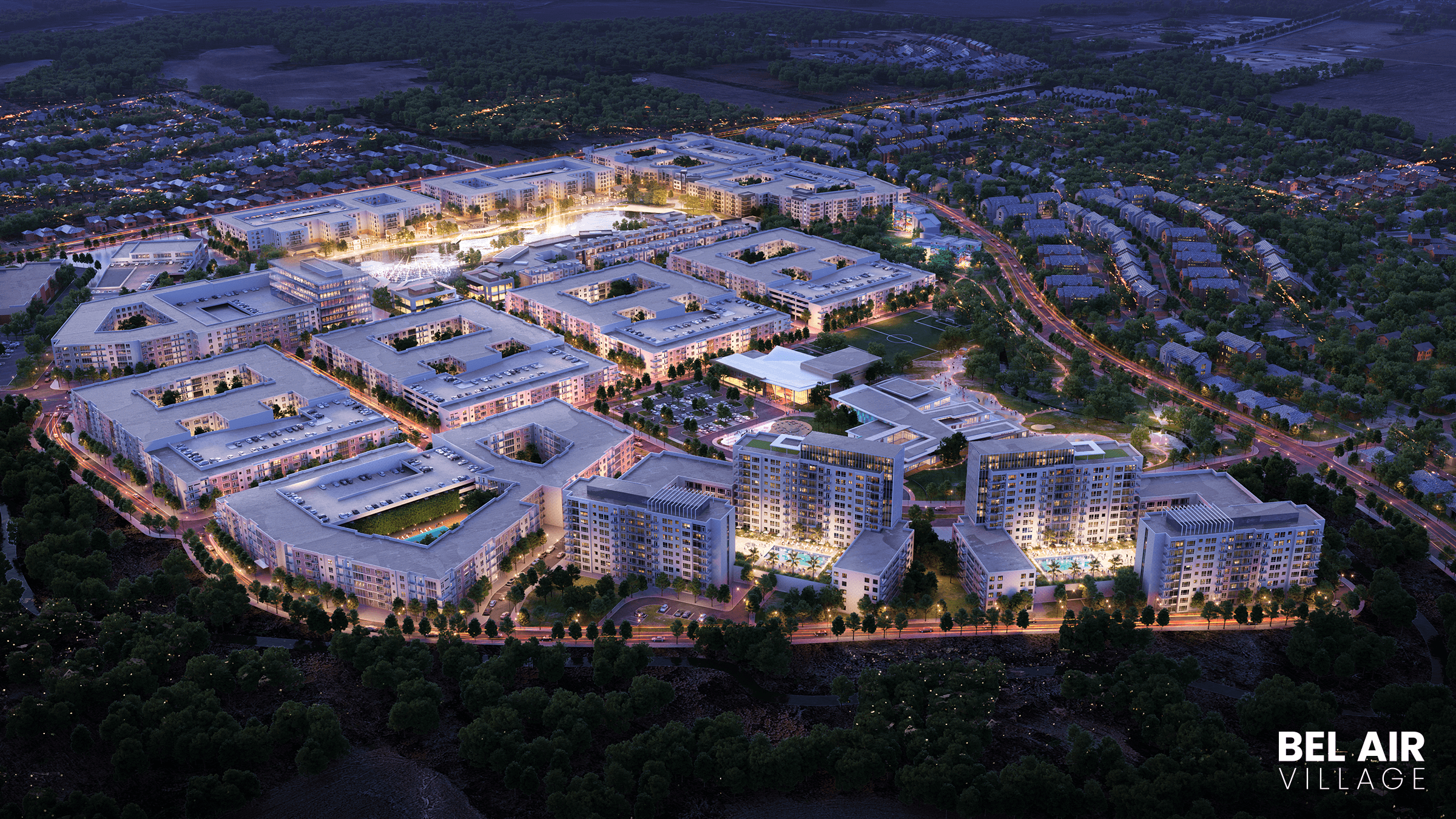 Aerial view of Bel Air Village at dusk, featuring luxurious apartments with white rooftops and surrounding green landscape.