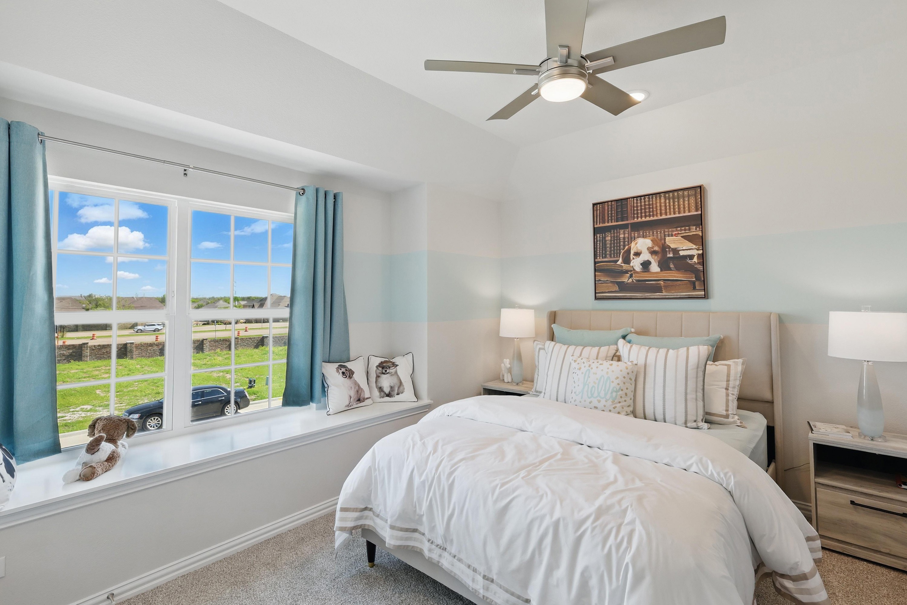 Elegant bedroom with large window, plush bedding, ceiling fan, and rural view in Green Oaks Preserve.