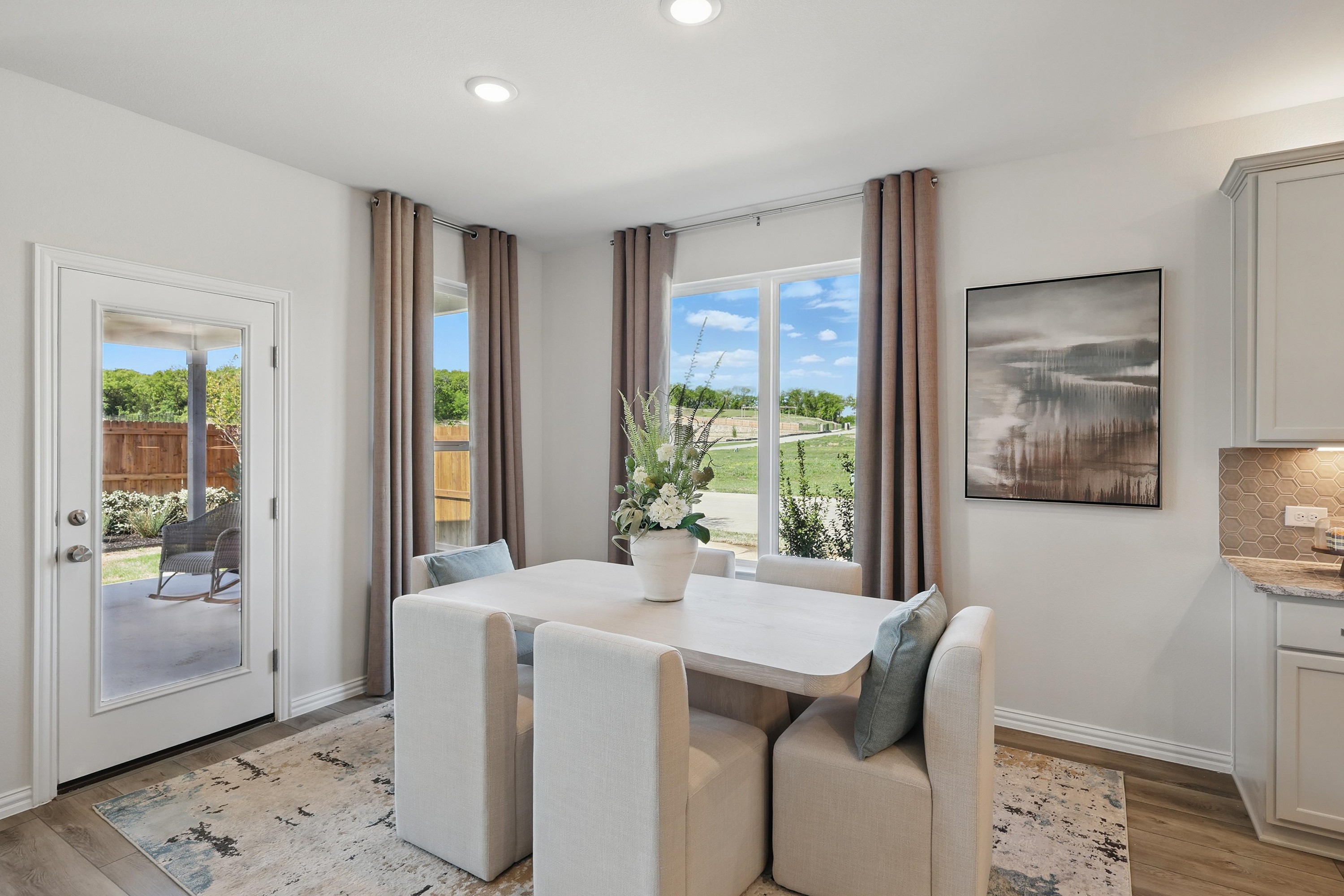 Elegant dining area with natural light, modern decor, and outdoor view at Green Oaks Preserve.