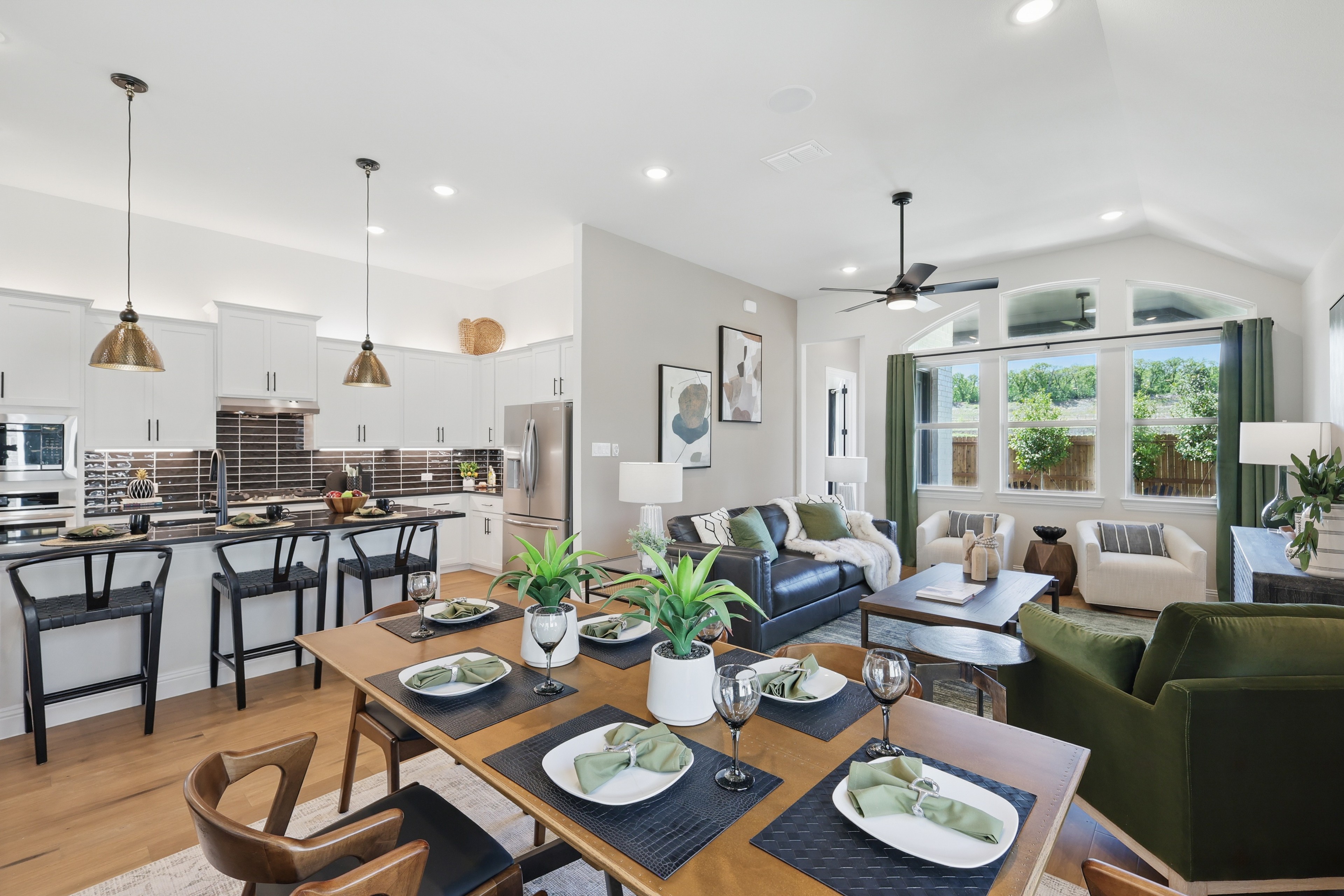 Elegant open-concept kitchen and living room with vaulted ceiling, modern fixtures in Green Oaks Preserve community.