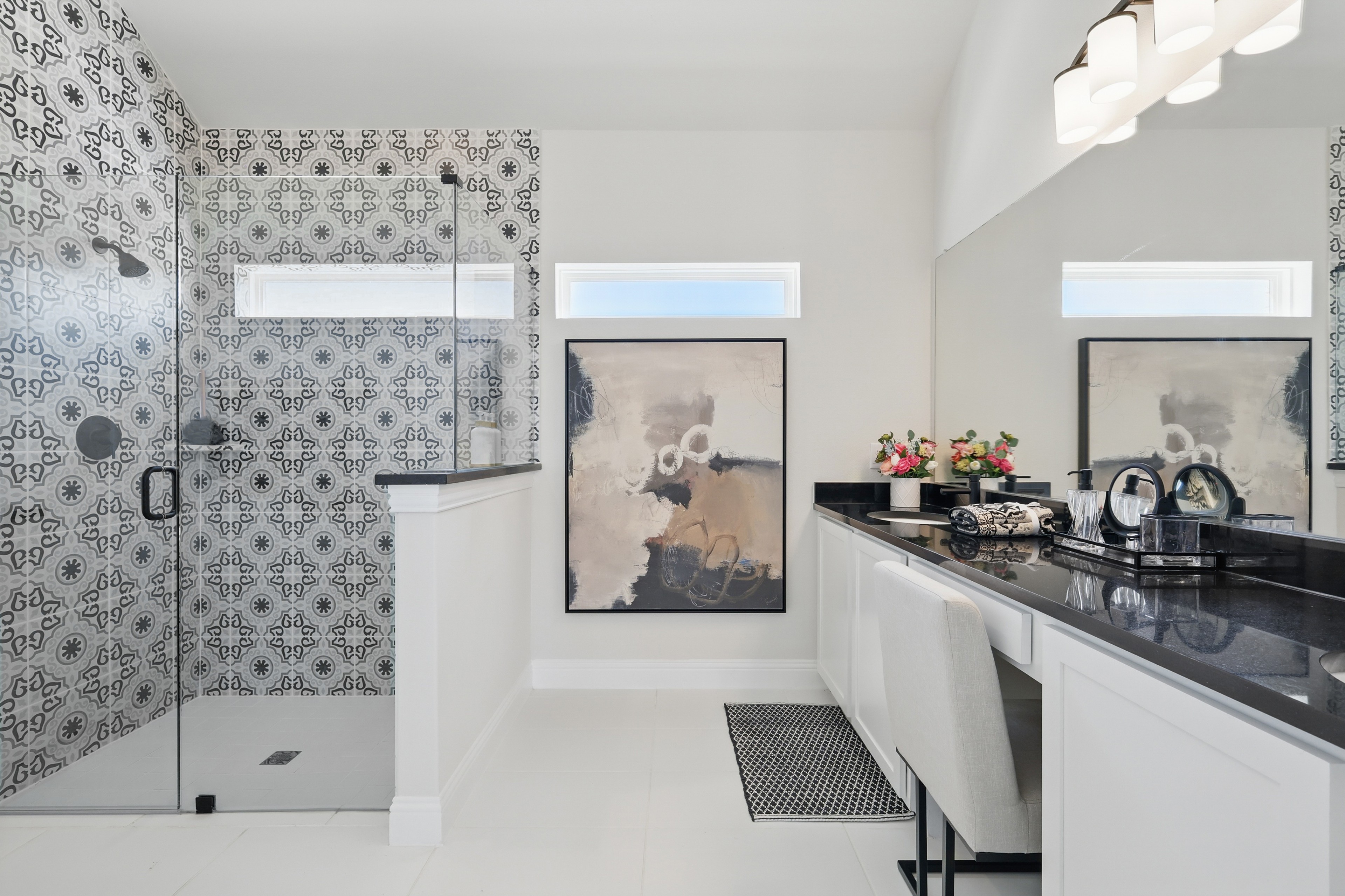 Elegant bathroom in Green Oaks Preserve with glass shower, patterned tiles, sleek countertop, and modern decor.
