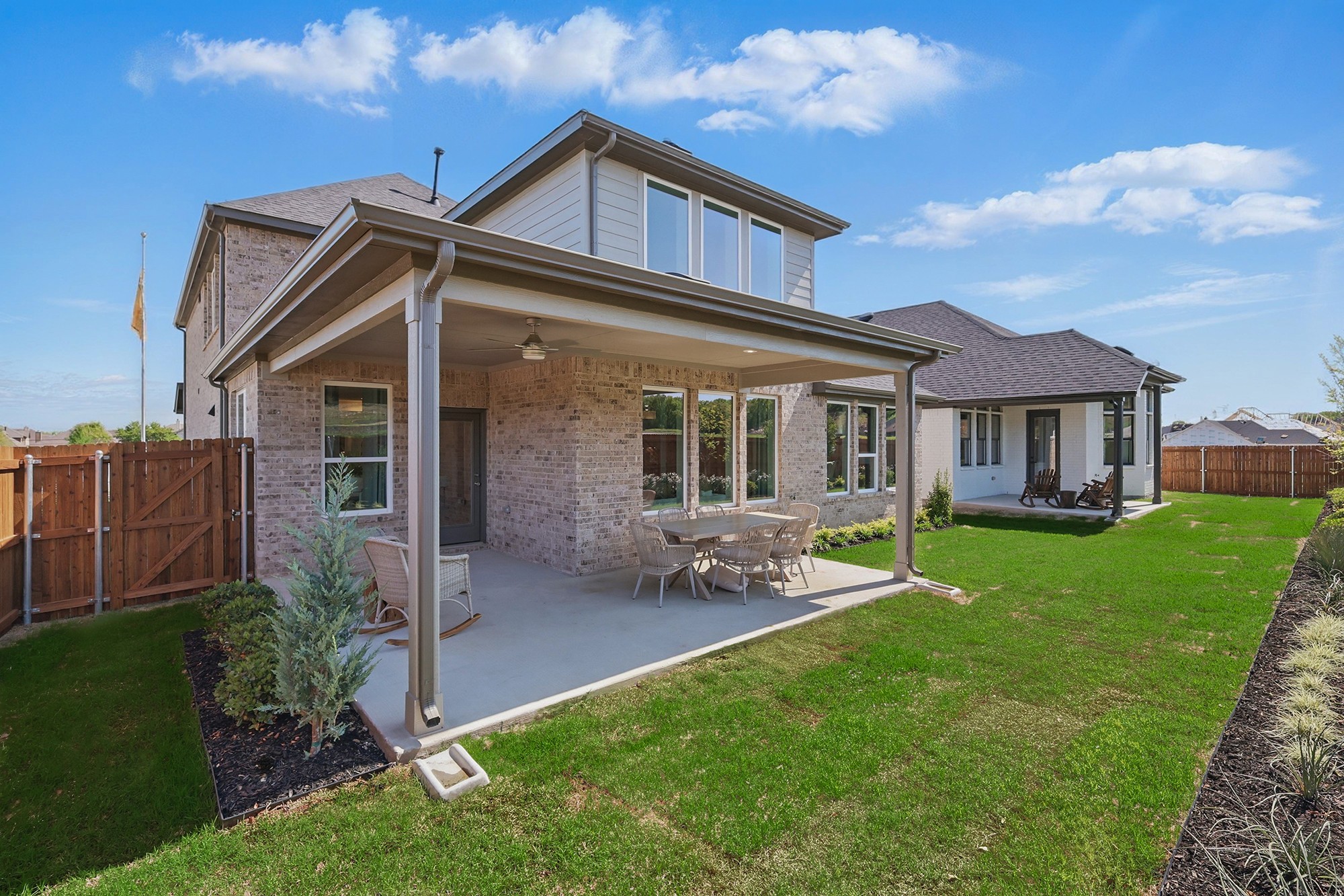 Luxurious Green Oaks Preserve home featuring brickwork, expansive yard, covered patio, and modern architecture.