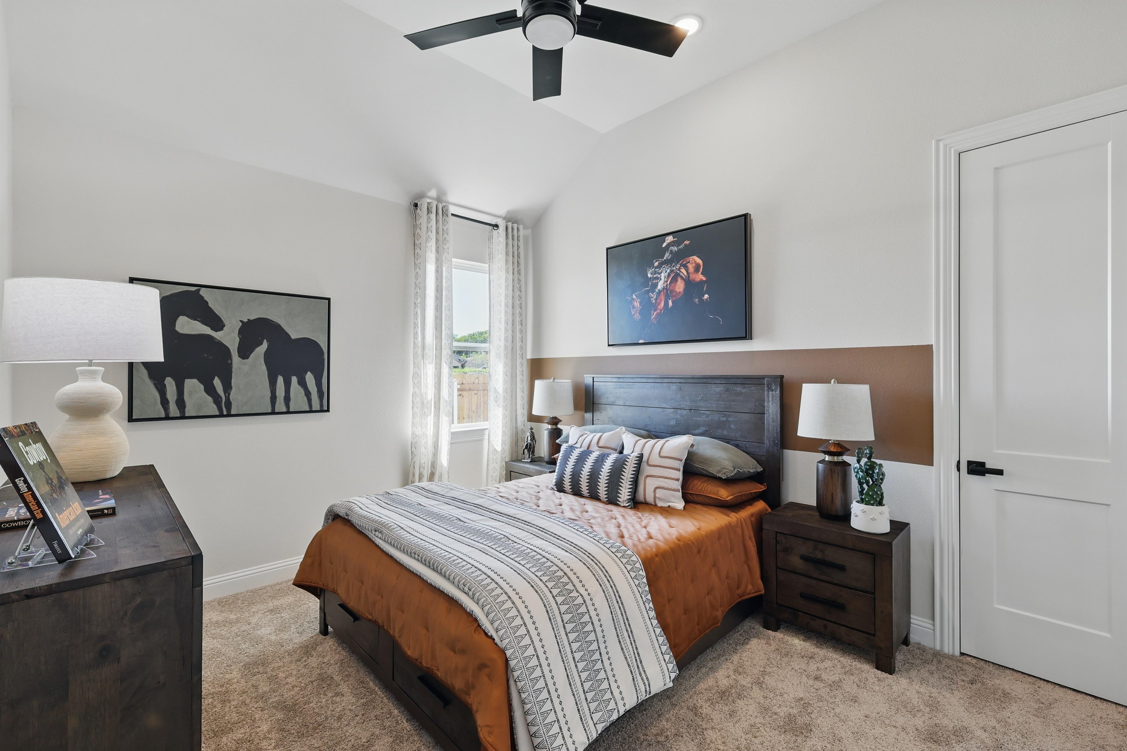 Elegant bedroom at Green Oaks Preserve, featuring horse artwork, vaulted ceiling, and modern decor.