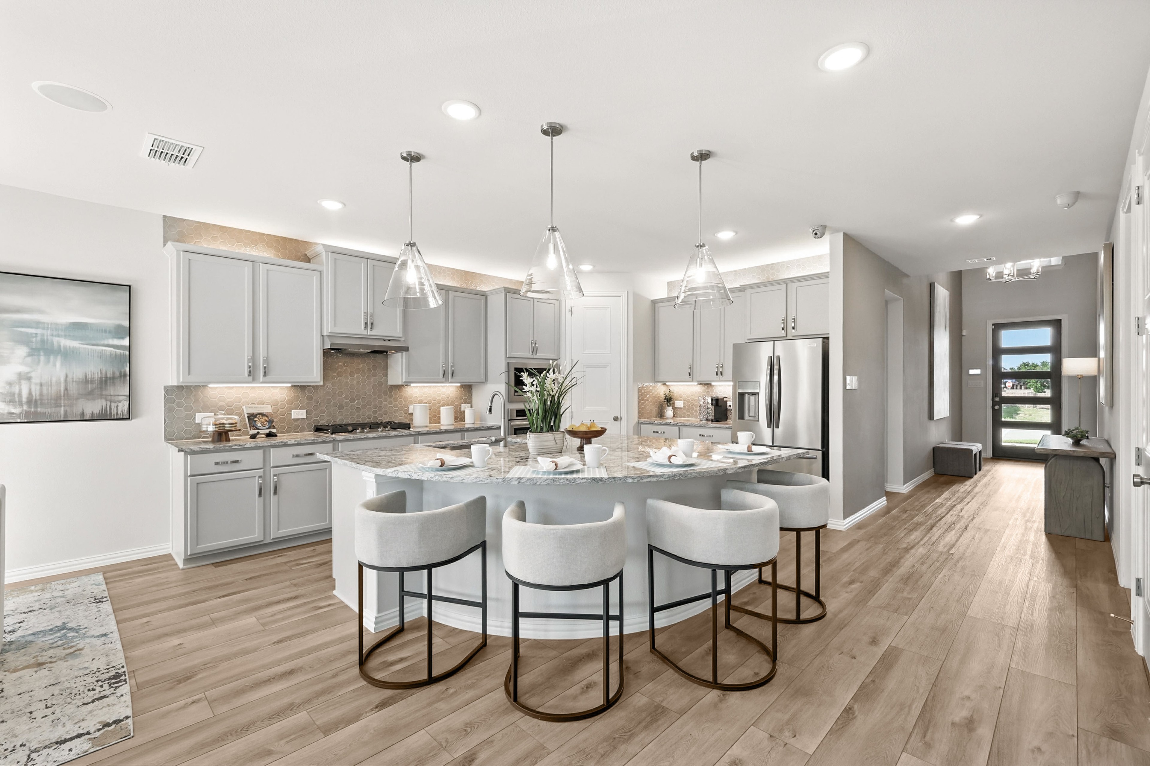 Modern kitchen with marble island, sleek cabinetry, pendant lighting in Green Oaks Preserve.