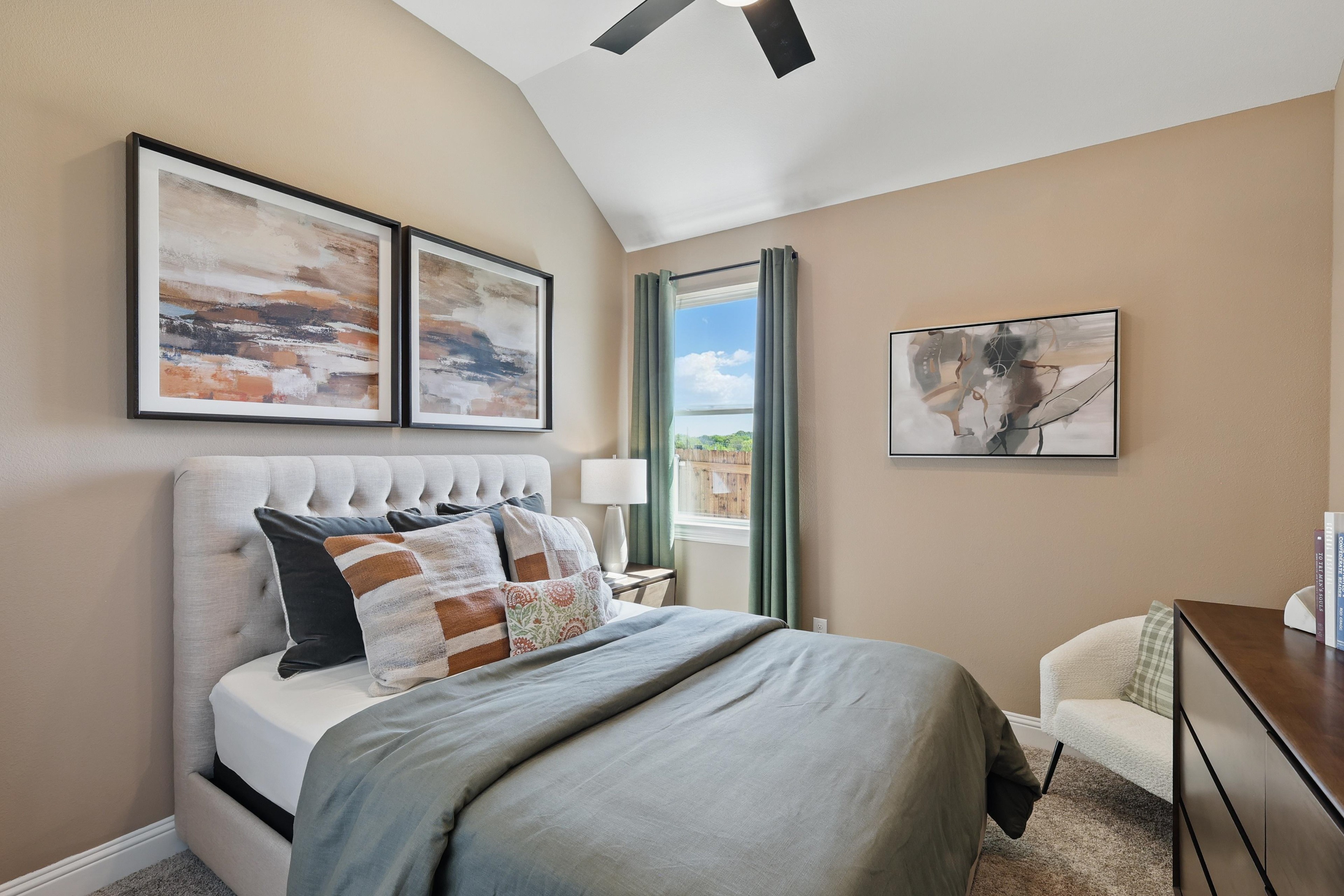 Elegant bedroom with vaulted ceiling, abstract art, plush bed, in Green Oaks Preserve.