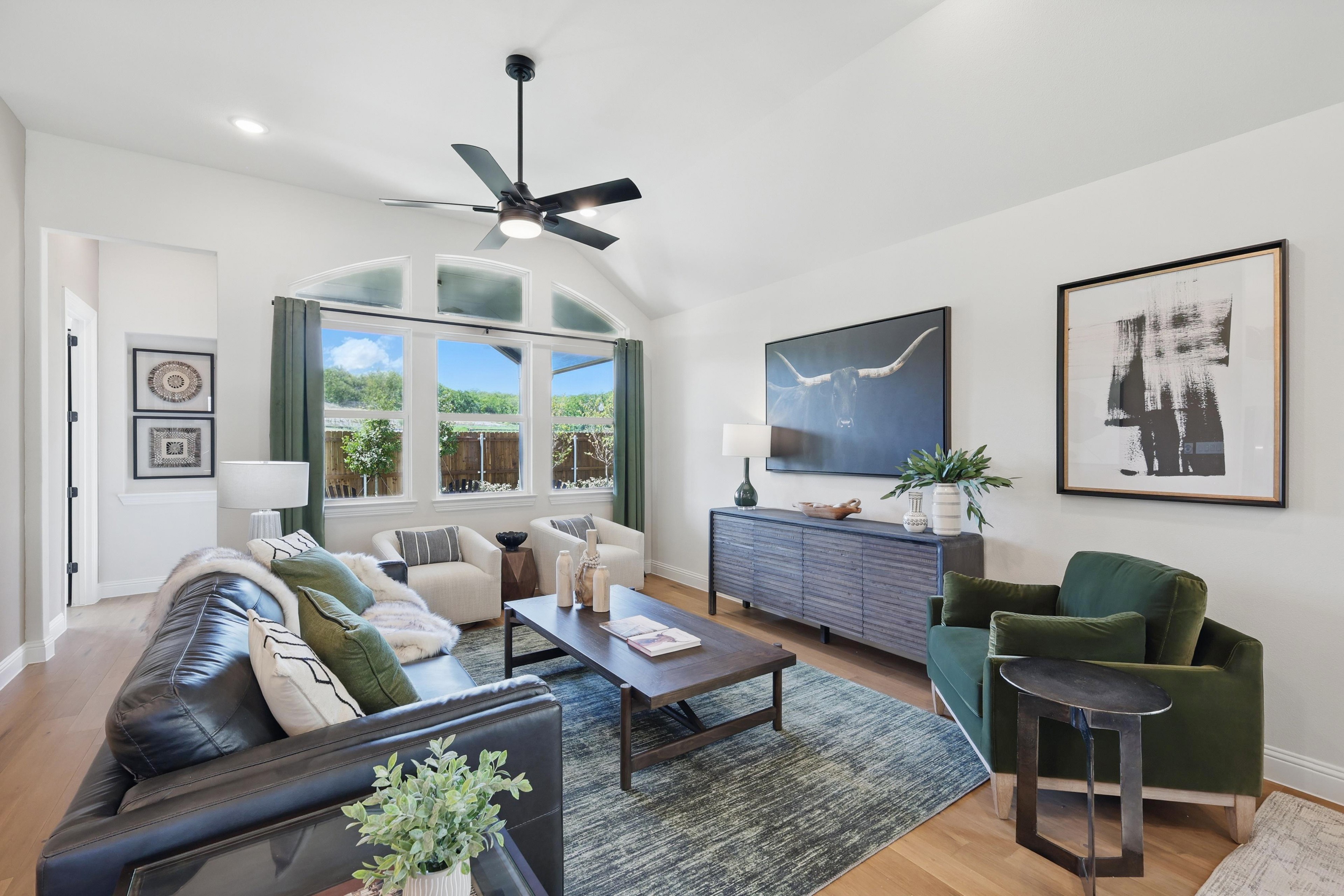 Modern living room with vaulted ceiling, arched window, elegant decor in Green Oaks Preserve.