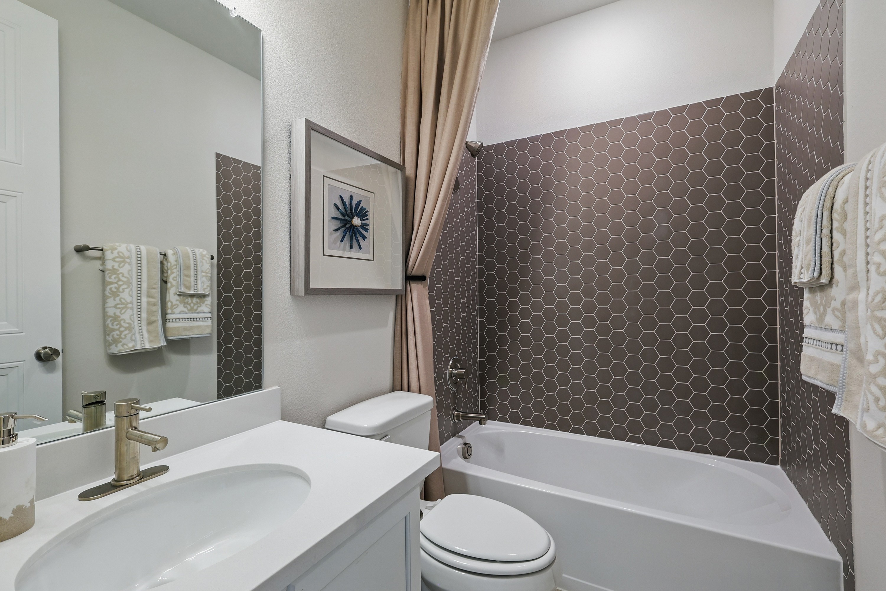 Luxurious bathroom with hexagonal tiles and elegant fixtures, Green Oaks Preserve community.