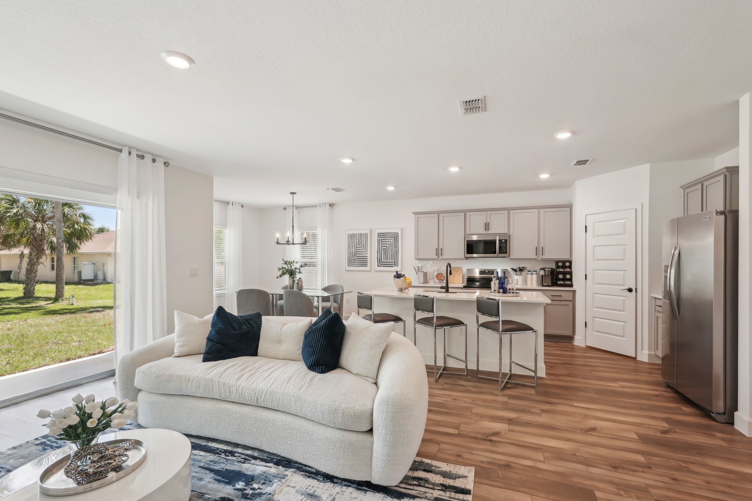 Modern North Port open-plan kitchen with gray cabinetry, hardwood floors, and cozy living area.