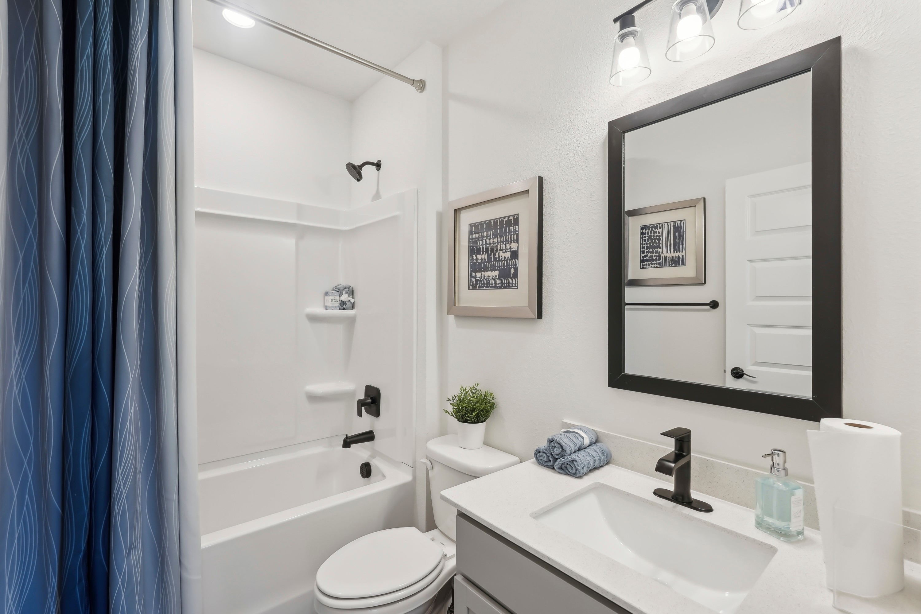 Modern North Port bathroom with black fixtures, framed mirror, and white vanity.