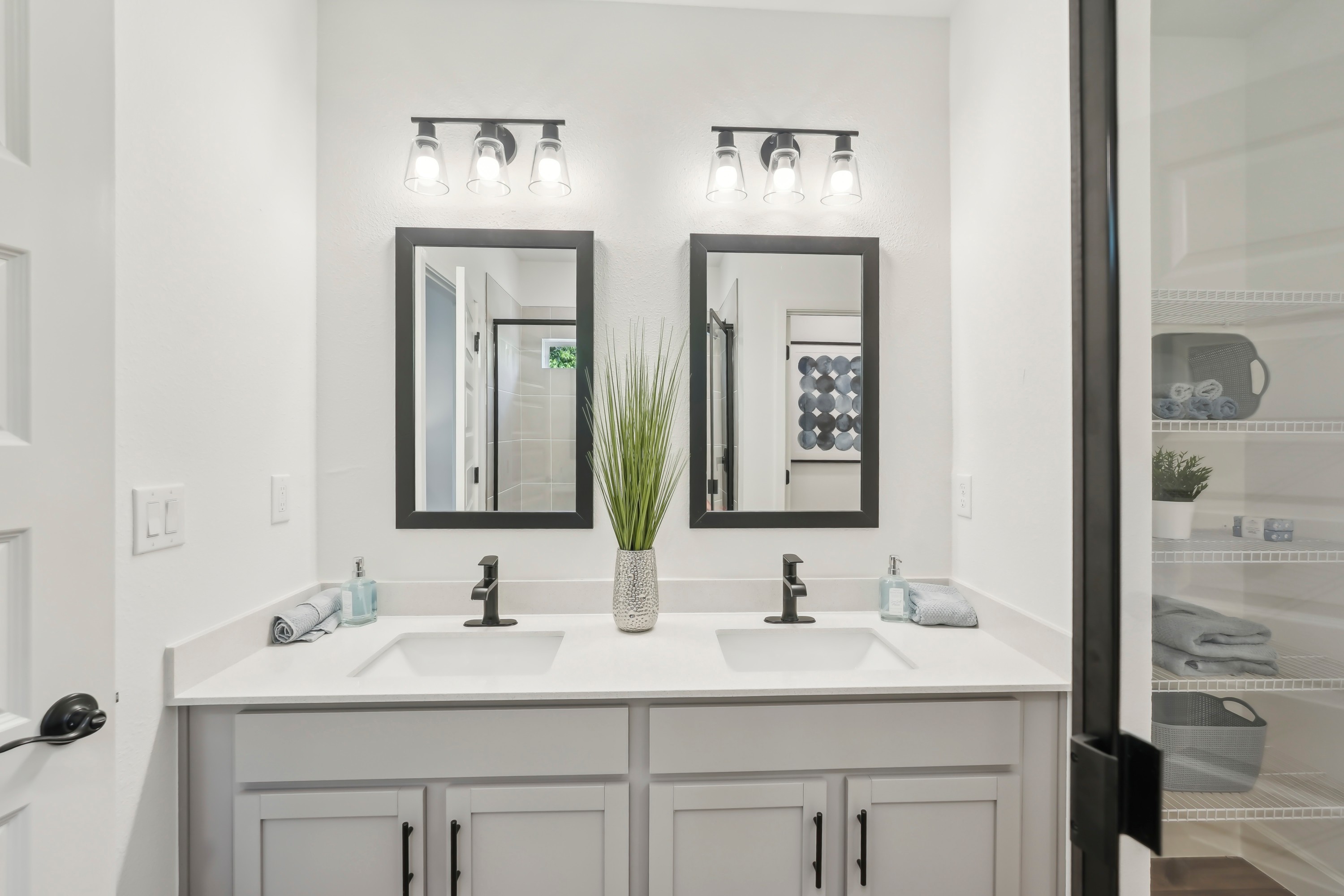 Modern double vanity with black-framed mirrors and sleek faucets in North Port home bathroom.