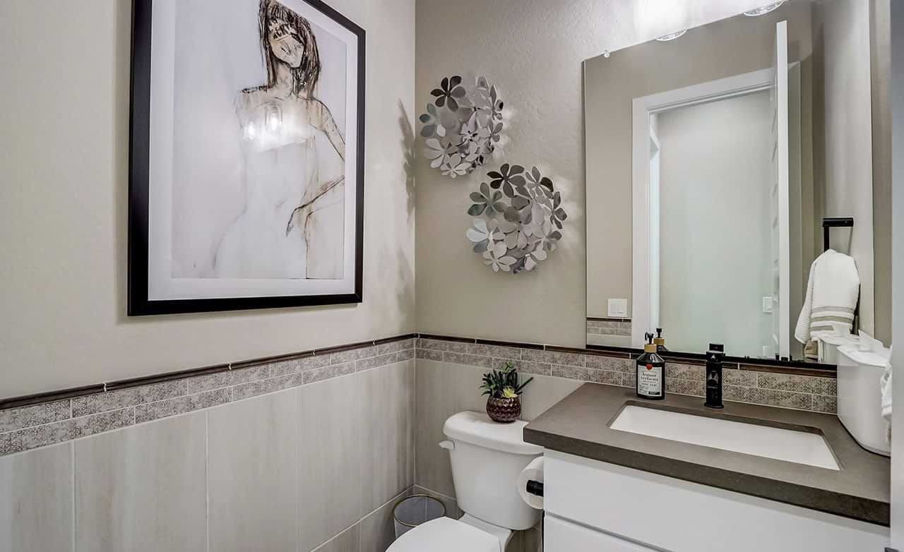 Elegant powder room with modern art, decorative wall accents, and stylish fixtures in Hacienda community.