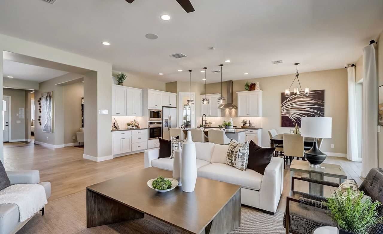 Elegant open-plan living room and kitchen, white cabinetry, hanging lights, modern decor, Canyon Views Hacienda.