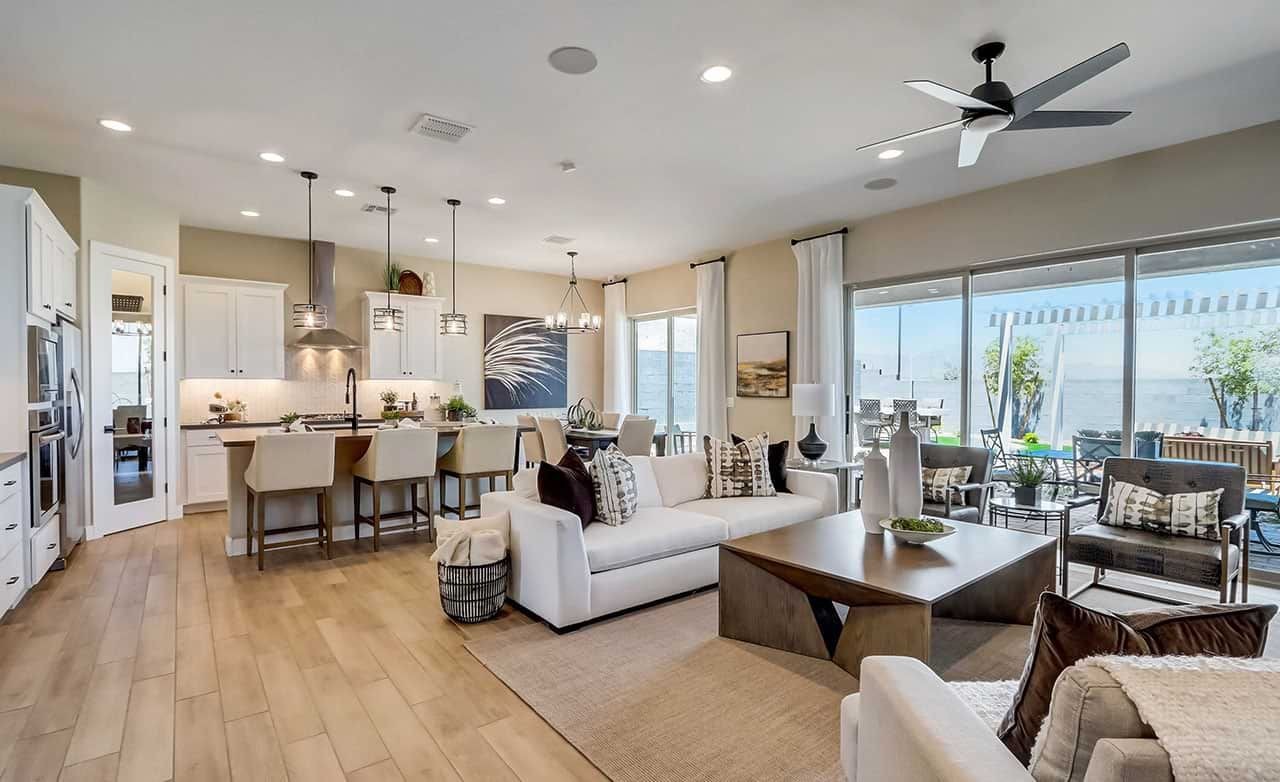 Modern open concept living room with kitchen, large windows, and canyon views in Hacienda community.