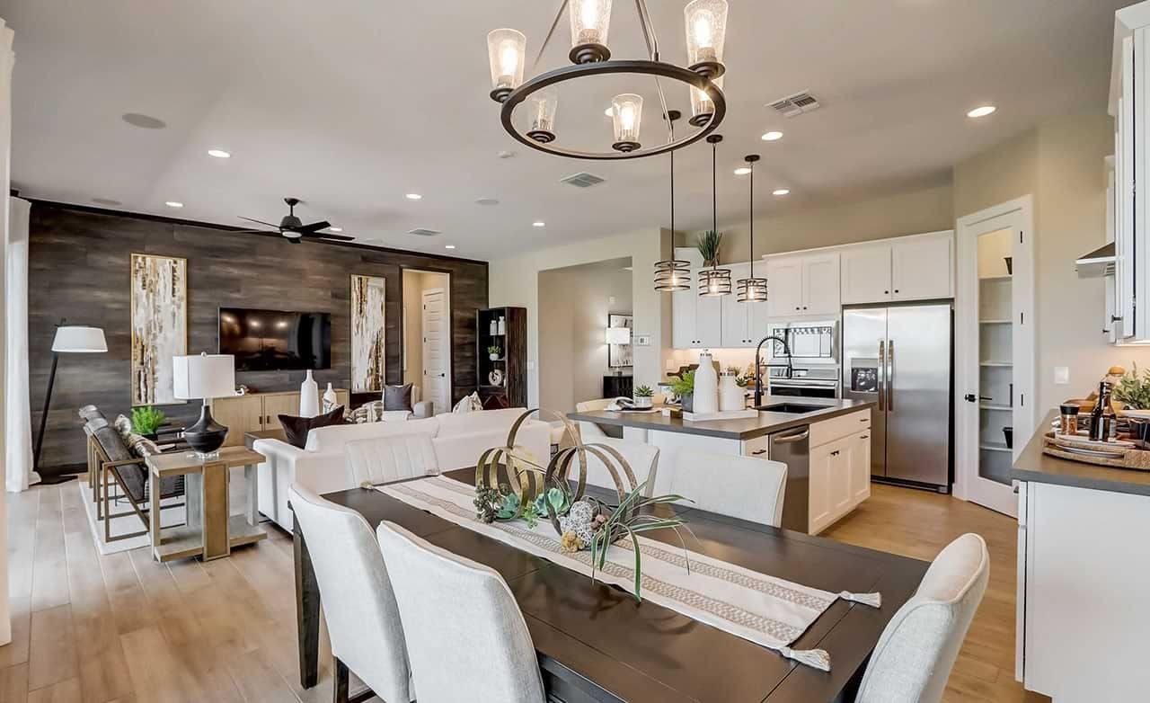 Open-concept living-dining room features elegant lighting, white cabinetry, wood accents at Canyon Views, Hacienda.