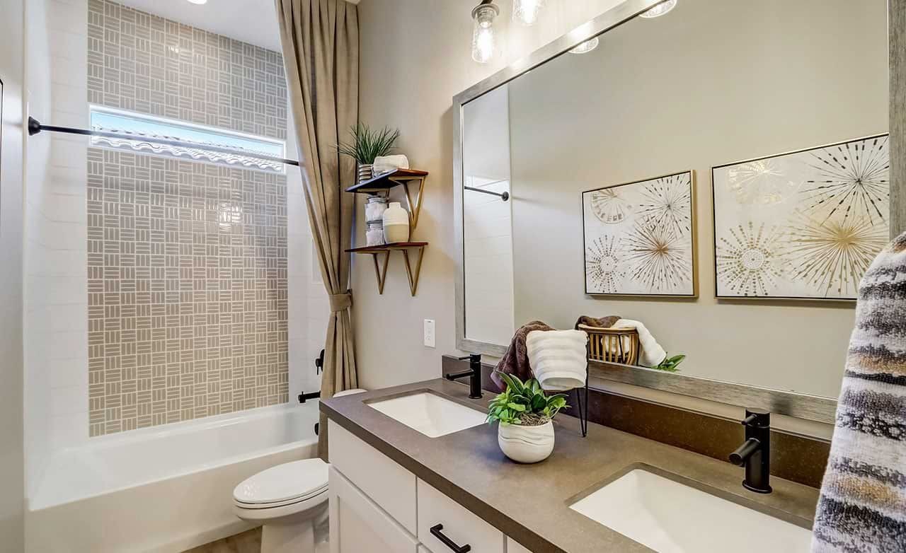 Elegant bathroom with dual vanity, geometric tile, and modern fixtures in Canyon Views Hacienda community.