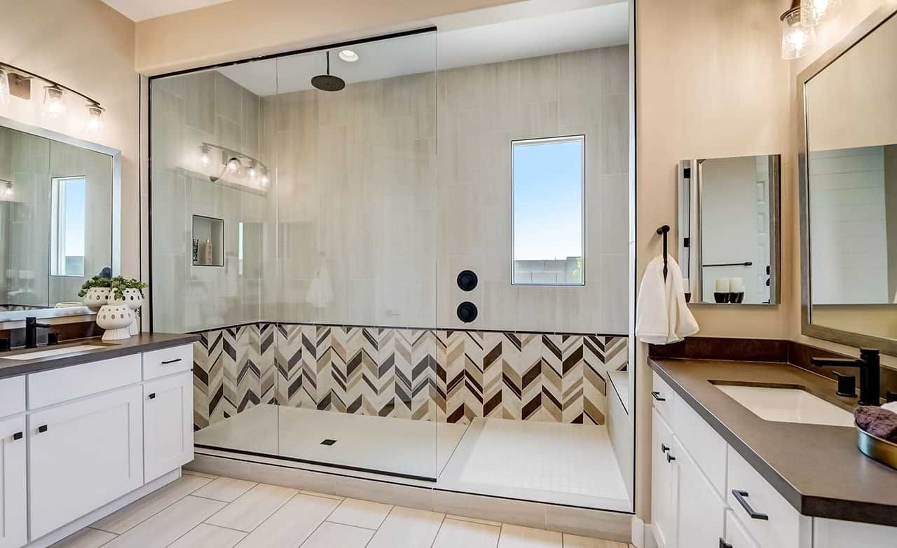 Luxurious bathroom in Hacienda home with large glass shower, chevron tiles, and double vanity, Canyon Views.