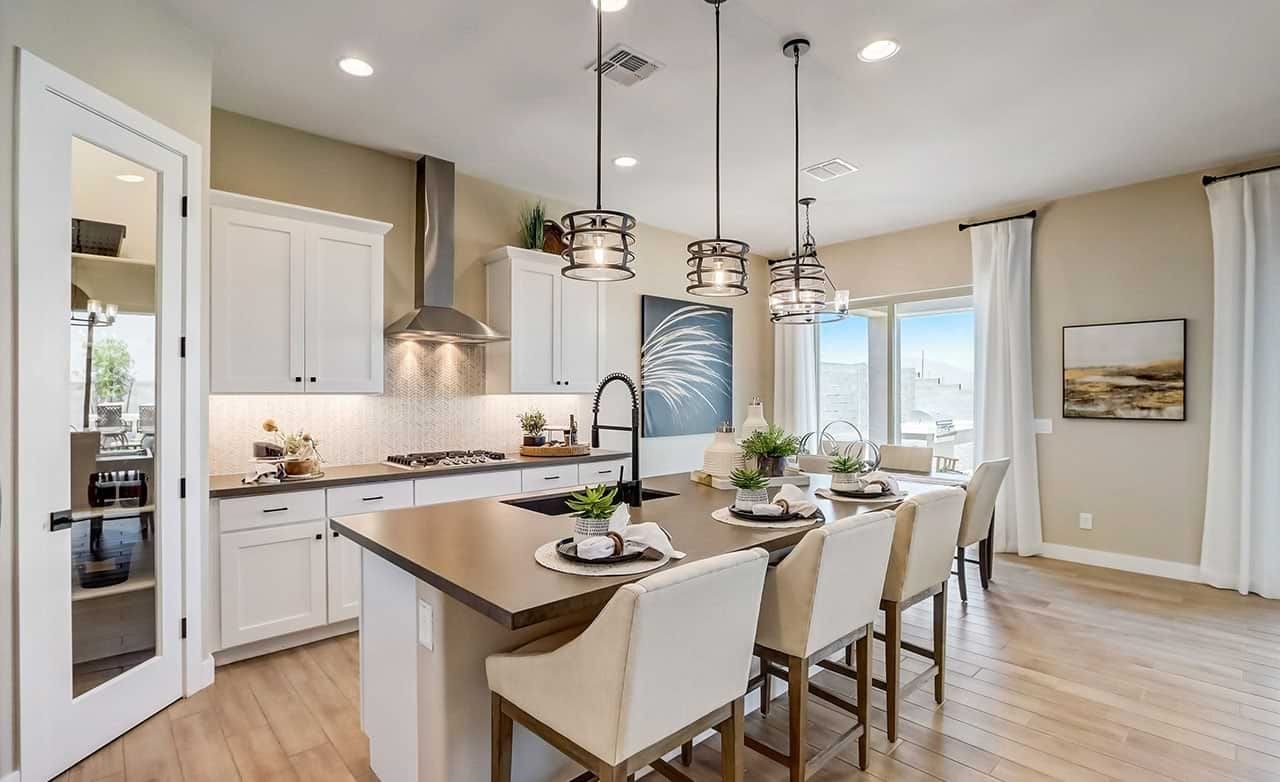 Modern kitchen in Hacienda home featuring pendant lights, island, and panoramic windows in Canyon Views community.