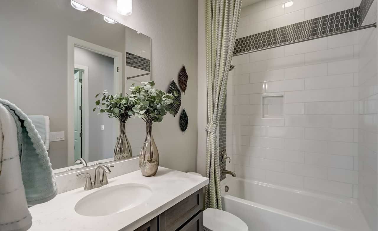 Luxurious bathroom with white tiles, elegant fixtures, glass vases; Canyon Views, Hacienda.