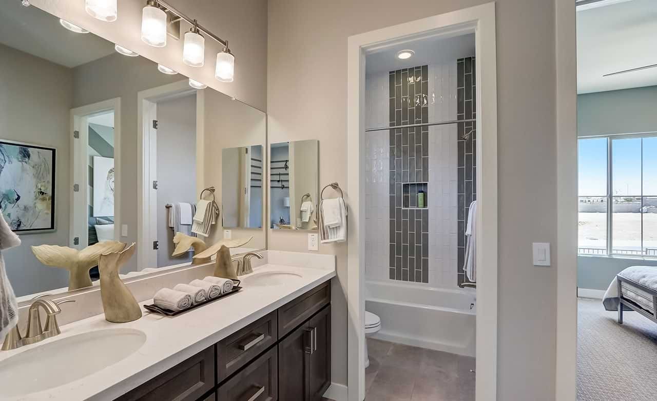 Modern bathroom with double sink, large mirror, stylish fixtures in Hacienda community near Canyon Views.