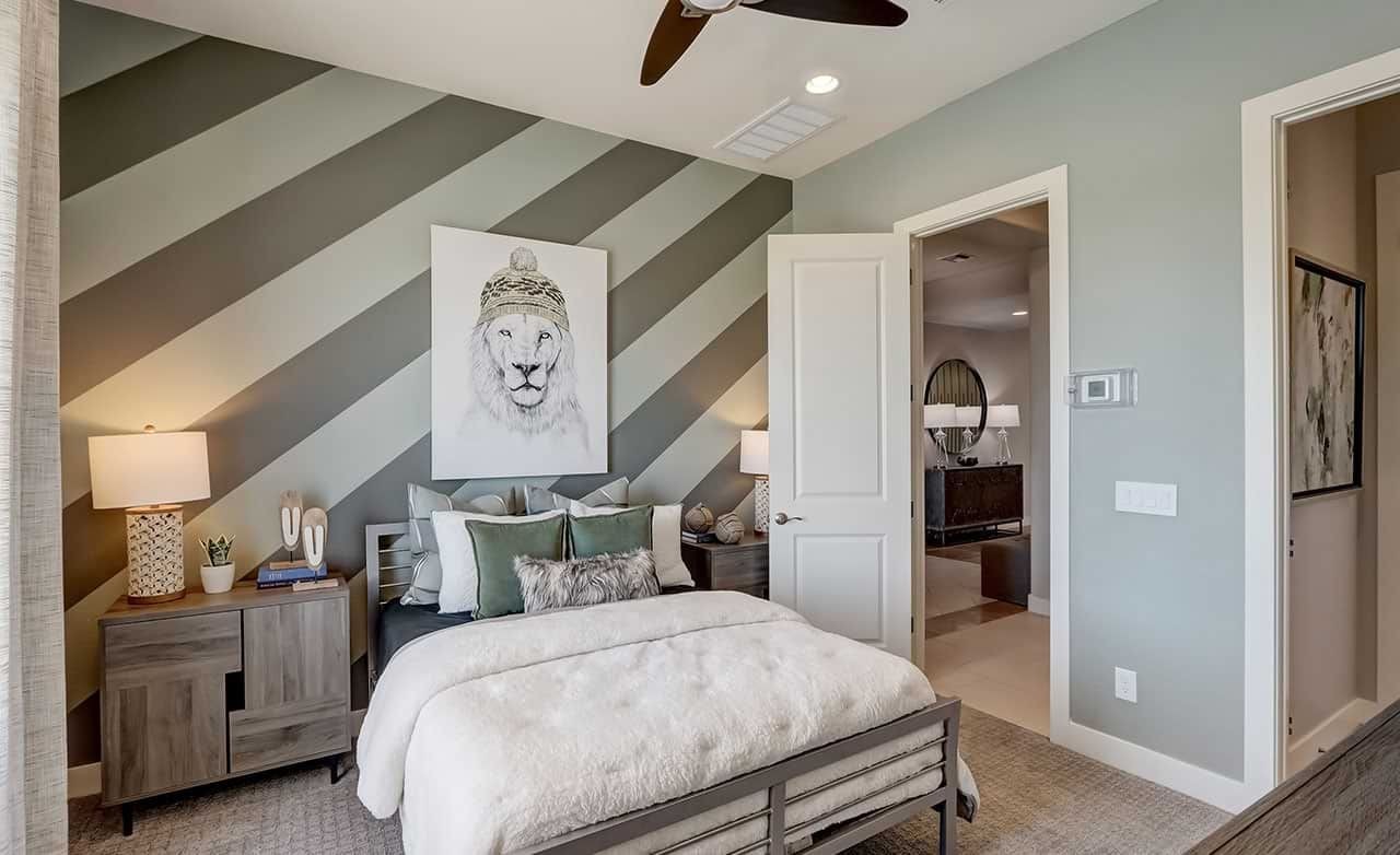 Elegant bedroom with diagonal striped wall, lion artwork, modern furniture in Hacienda community.