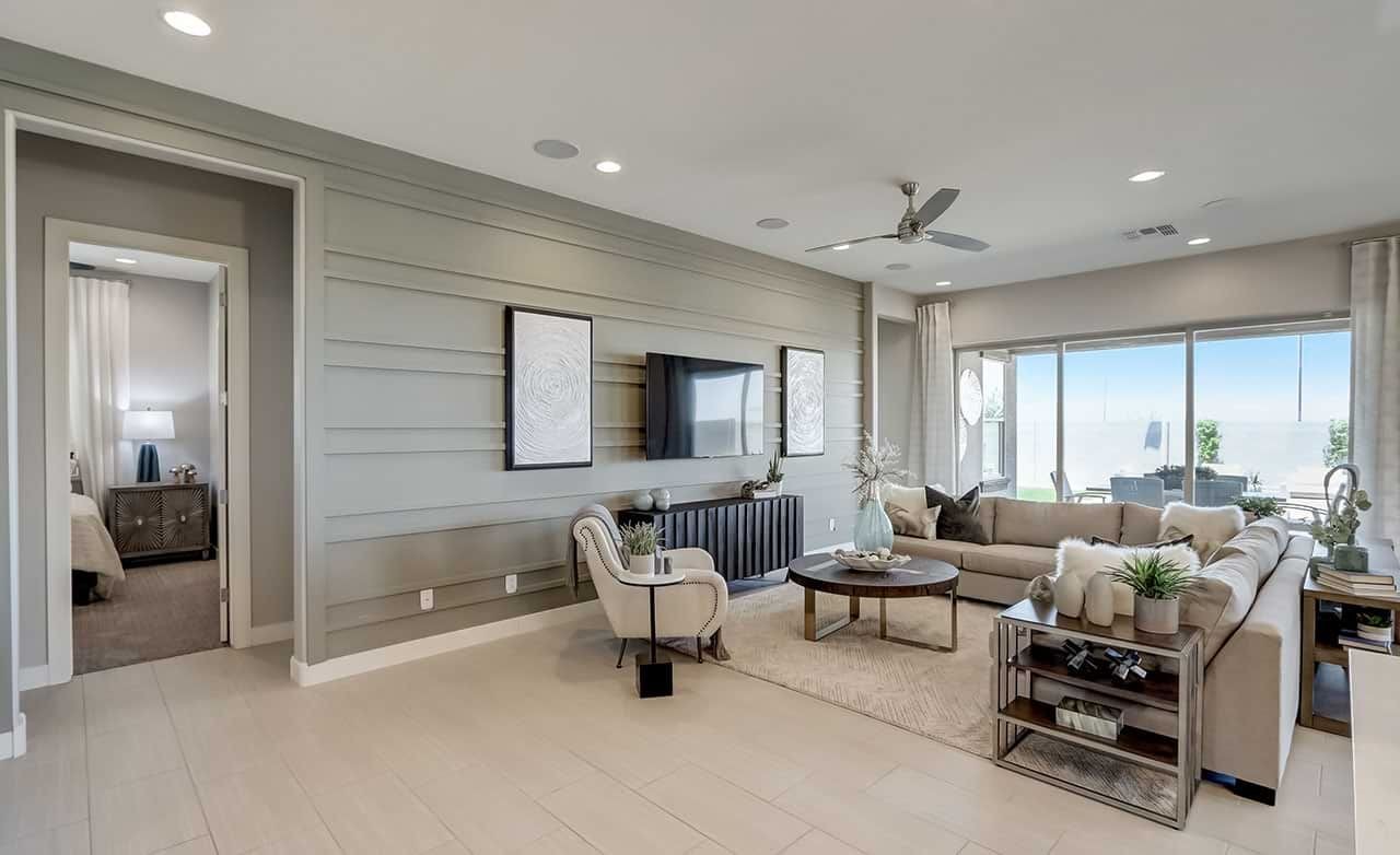 Luxurious living room in Hacienda community with sleek modern decor, large windows, and integrated entertainment unit.