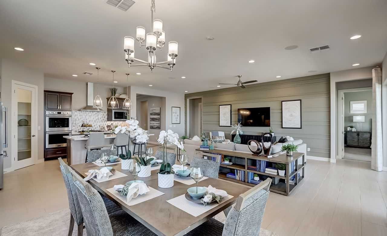 Modern open-concept living room and kitchen in Hacienda community. Features sleek cabinetry, elegant lighting, and a cozy ambiance.