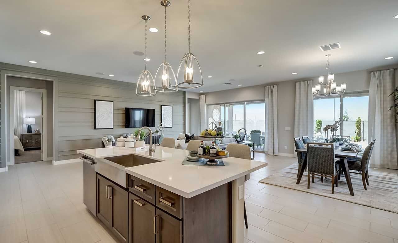 Spacious modern kitchen and dining area with stylish lighting, large windows, and sleek finishes in Hacienda community.