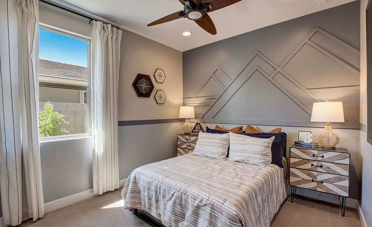 Modern bedroom in Castillo at Anderson Parc with geometric accent wall and unique side tables.