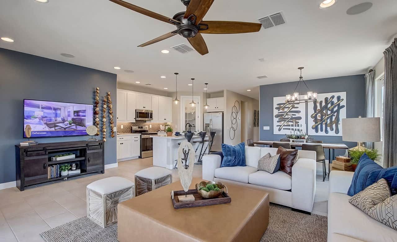 Stylish living room with sleek ceiling fan, chic decor, and open kitchen at Anderson Parc, Arizona.