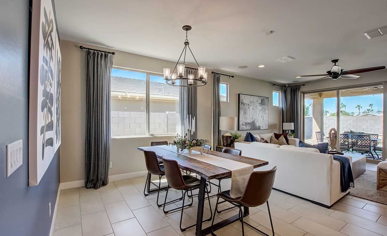 Elegant dining room in Castillo at Anderson Parc with modern chandelier, tile floor, and large window.