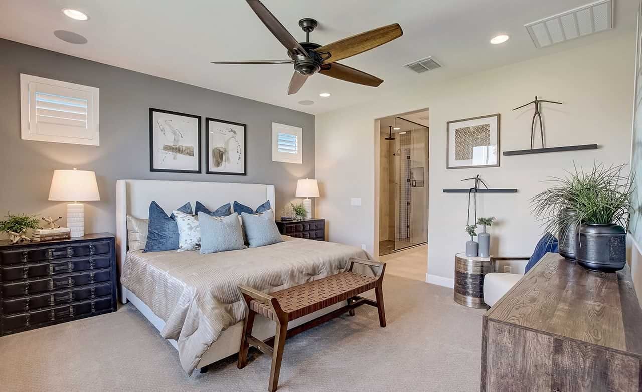 Elegant Anderson Parc bedroom with modern fan, wall art, neutral tones, and en-suite bathroom.