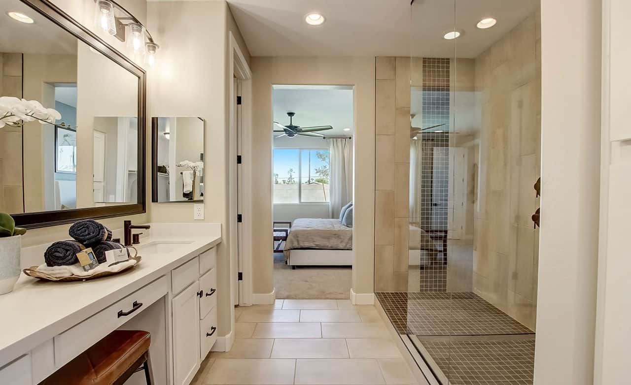 Modern bathroom with elegant vanity, large mirror, and spacious shower in Anderson Parc home.