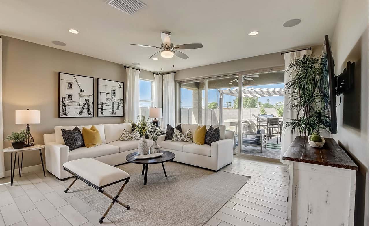 Modern living room with white sofas, abstract art, sliding glass doors, tile flooring at Castillo, Anderson Parc.