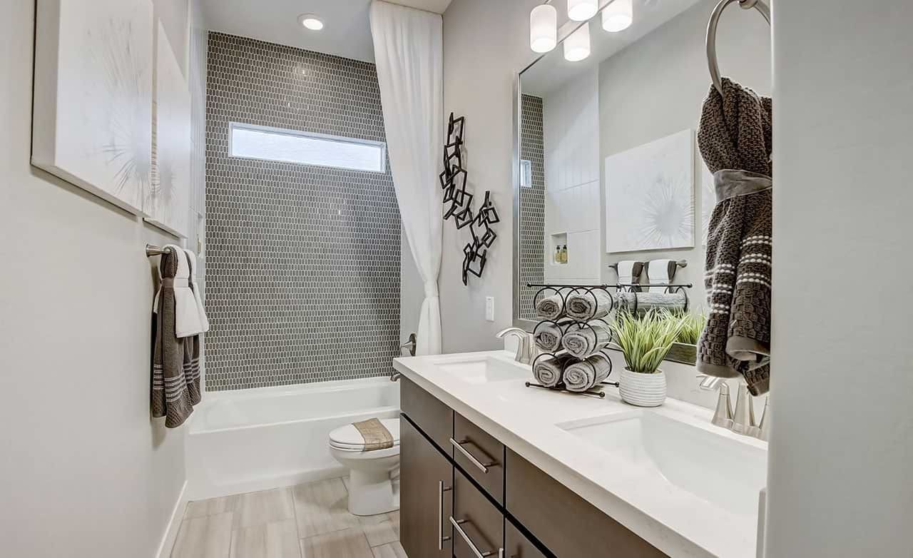 Elegant bathroom with mosaic tile wall, sleek vanity, and modern lighting at Mirada Crossing.
