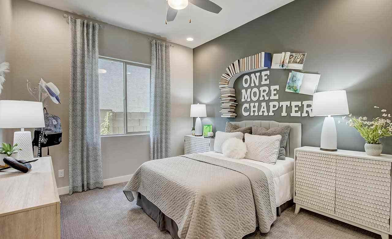 Elegant bedroom in Mirada Crossing with book-themed wall art and contemporary decor.