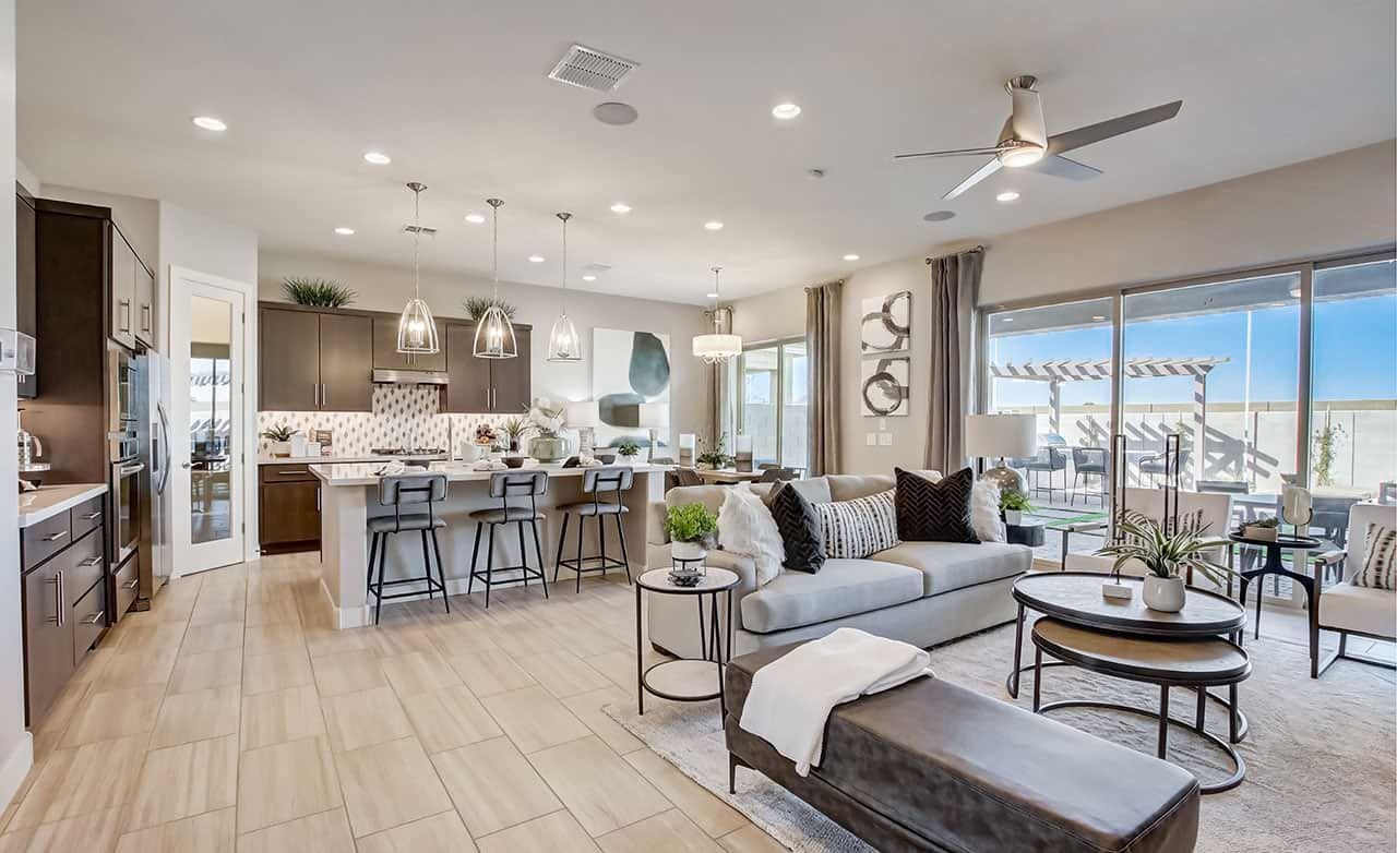 Modern open-plan living area with sleek kitchen island, Mirada Crossing, large windows, elegant light fixtures.