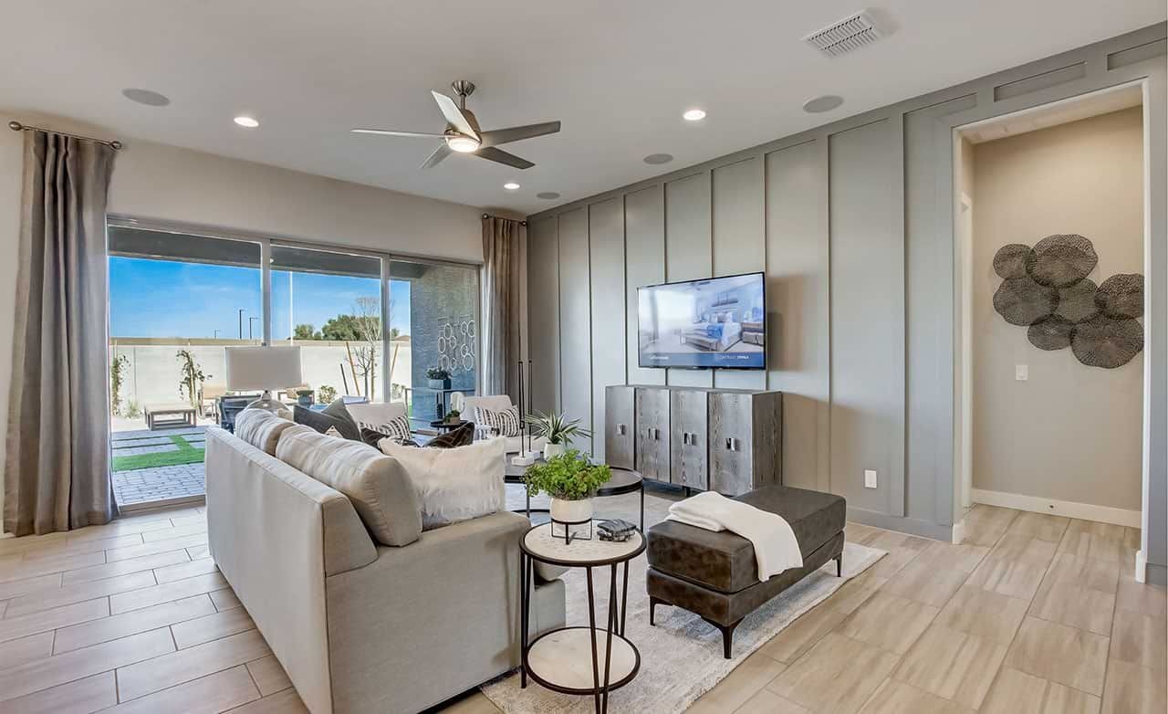 Modern living room with paneled walls, large windows, and sleek decor in Mirada Crossing community.