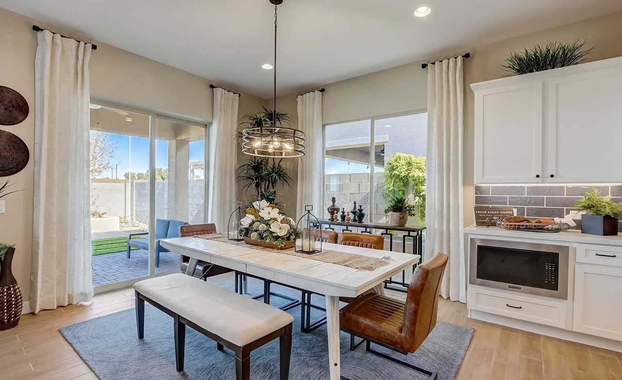 Elegant dining room with large windows, chic light fixture, and modern decor in Mirada Crossing community.