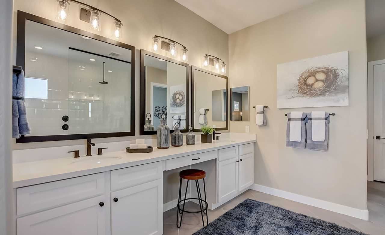 Luxurious bathroom with dual vanity, framed mirrors, and modern lighting at Mirada Crossing.