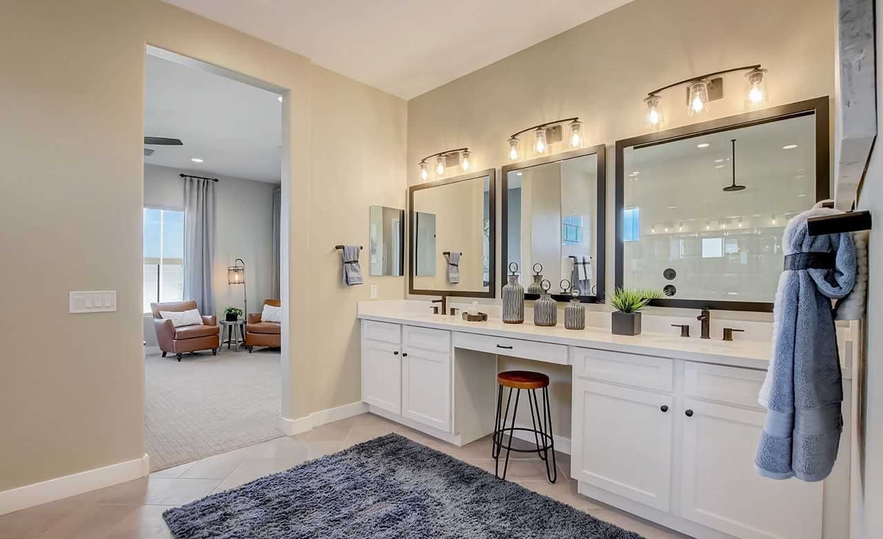 Luxurious bathroom with double vanity, large mirrors, modern lights in Mirada Crossing community.