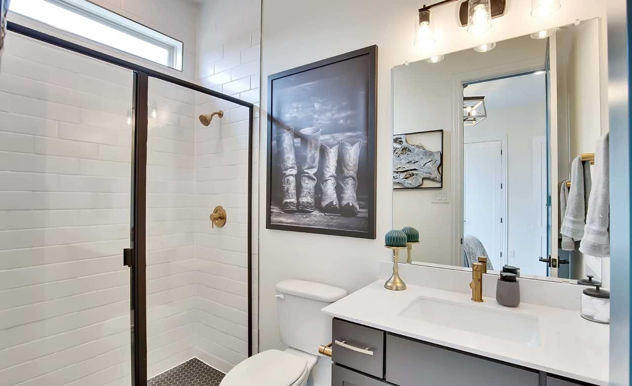 Modern bathroom with glass shower, sleek vanity, and decor accents in Oaks at San Gabriel.