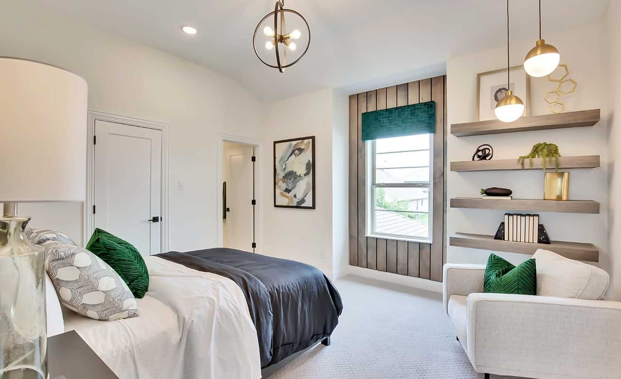 Modern bedroom with elegant decor, built-in shelves, and stylish lighting in Oaks at San Gabriel community.