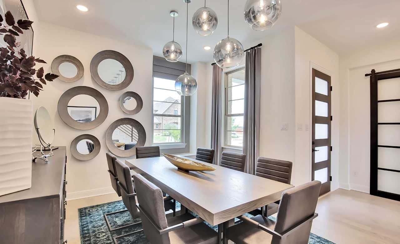 Modern dining room with round mirrors, globe lights, and large windows in Oaks at San Gabriel neighborhood.