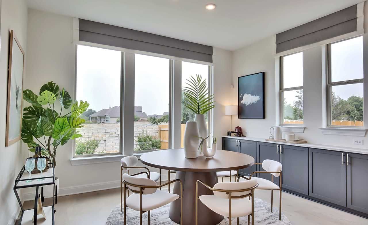 Elegant dining area with large windows, modern furniture in Oaks at San Gabriel, Georgetown, TX.