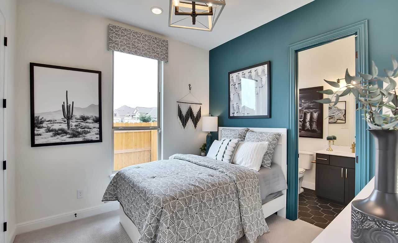 Bedroom with modern decor, teal accent wall, cactus art, and window. San Gabriel home luxury interior design.