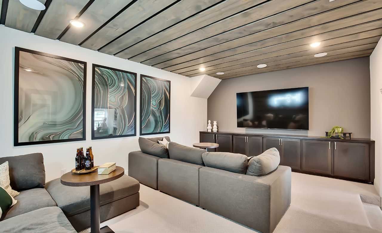 Luxury media room with modern wood ceiling, abstract art, plush sofa. Oaks at San Gabriel, Texas.